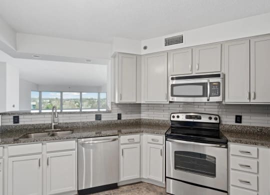 a kitchen with white cabinets and appliances and granite counter tops