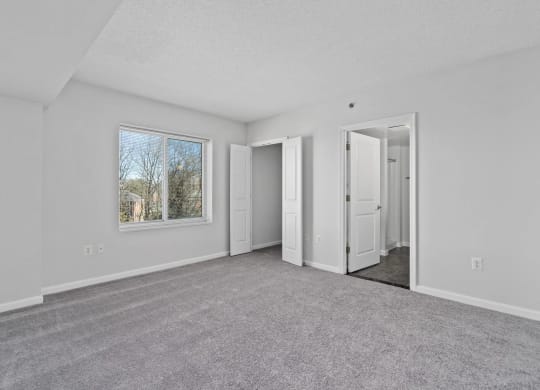 an empty living room with white walls and a window