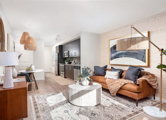 a living room with a brown leather couch and a white table