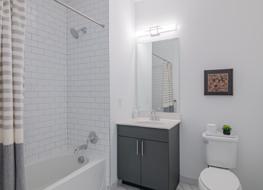 a white bathroom with a tub and a sink and a toilet