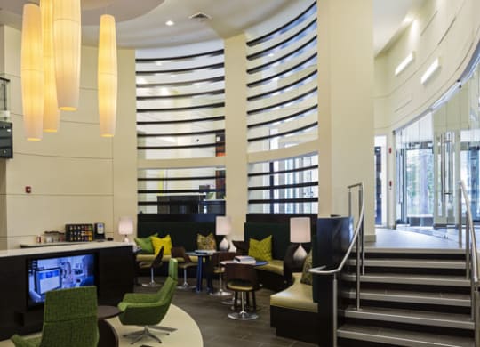 a lobby with chairs and tables and a staircase