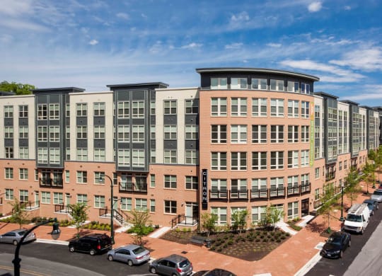 an exterior view of an apartment building with cars parked in front of it