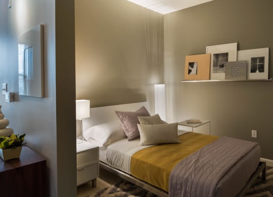 a bedroom with a bed with a yellow blanket and pillows