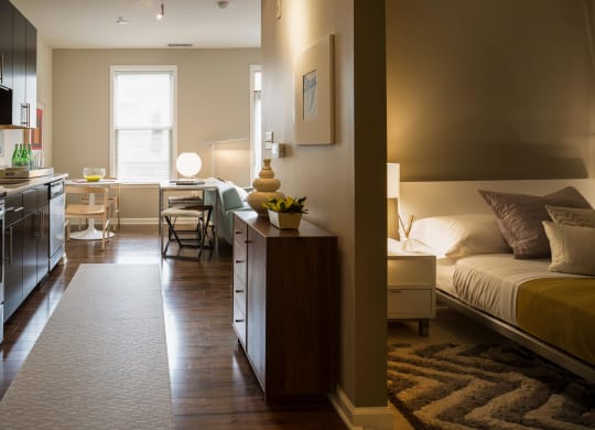a bedroom with a bed and a living room with a desk