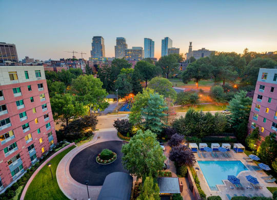 an aerial view of a swimming pool and a city at dusk