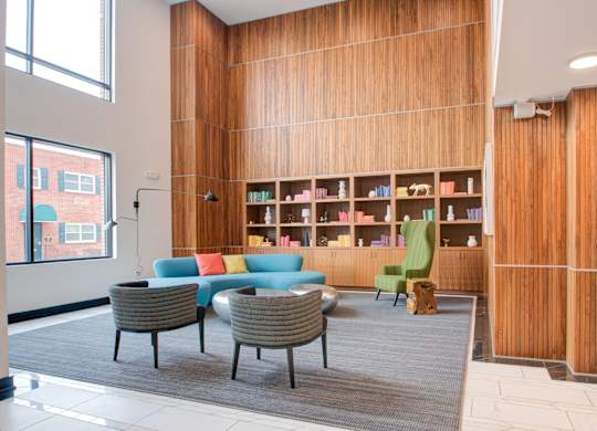 A room with a wooden bookshelf and a grey carpet.
