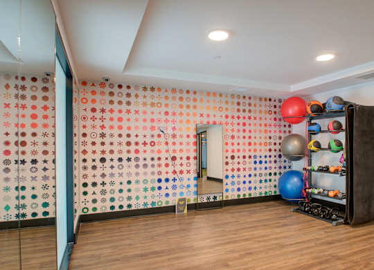 A room with a wall covered in buttons and a ball machine.