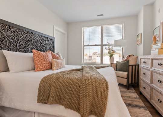 A bedroom with a large bed and a wooden headboard.