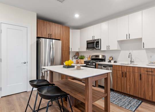 A kitchen with a table and chairs in front of a refrigerator.