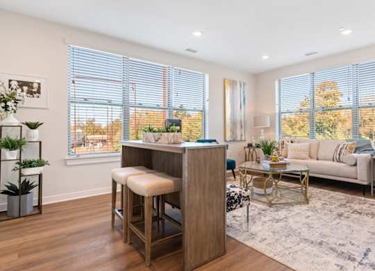 A modern living room with a bar stool and a couch.