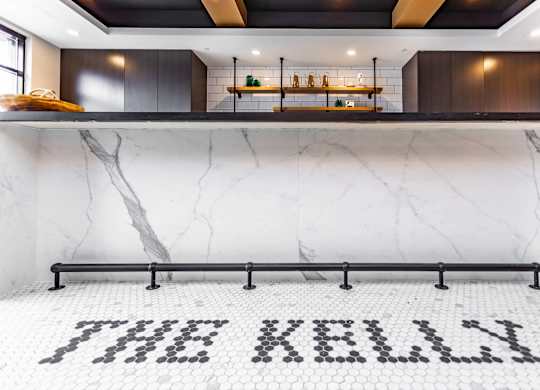A white marble floor with black letter tiles spelling out