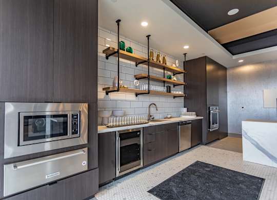 A modern kitchen with dark wood cabinets and stainless steel appliances.