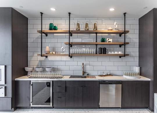 A modern kitchen with dark wood cabinets and a white backsplash.