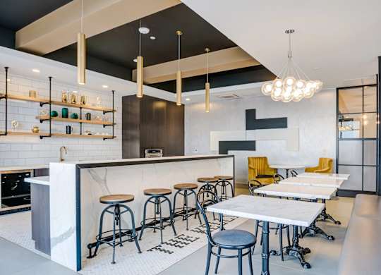 A modern bar with stools and a counter.