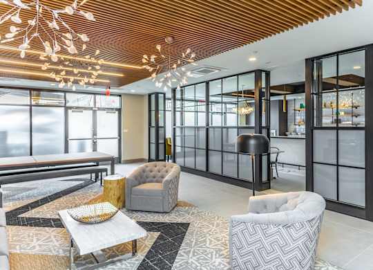 A modern living room with a wooden ceiling and glass walls.