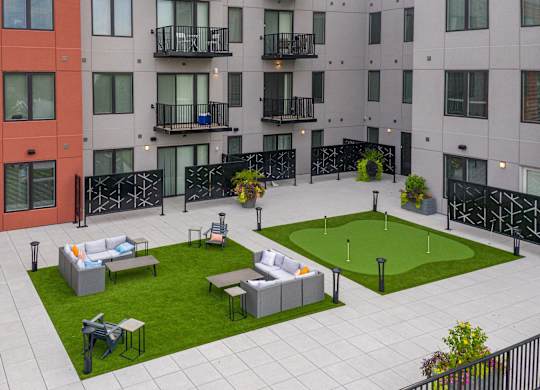 A modern apartment complex with a courtyard and seating area.