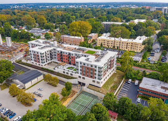 A large building with a tennis court in front of it.