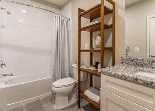 A bathroom with a toilet, sink, and shower.