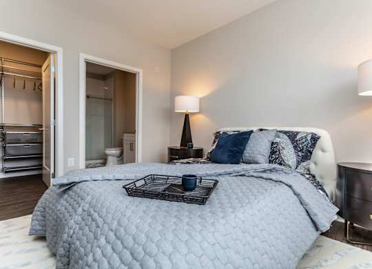 A bedroom with a large bed and a lamp.