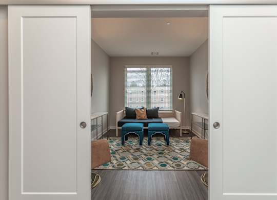 A room with a blue couch and a patterned rug.