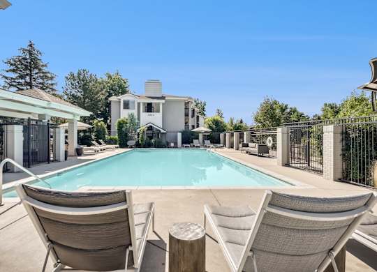 A pool surrounded by chairs and a house in the background at The Magwood in Boulder, Colorado.