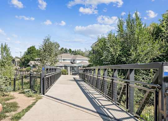 Wonderland Creek and Trail bridge with a metal railing connects two sides of a park at The Magwood in Boulder, Colorado.