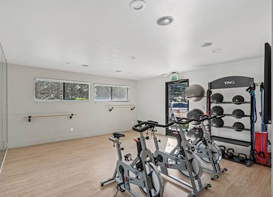 A gym with a mirror, weights, and exercise bikes at The Magwood in Boulder, Colorado.