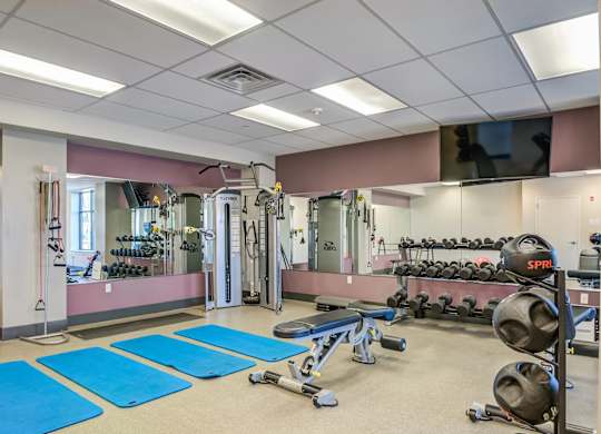 A gym with blue mats on the floor.