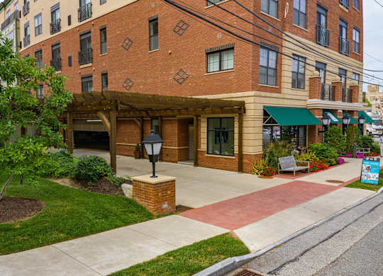 A brick building with a green awning and a lamp post in front.