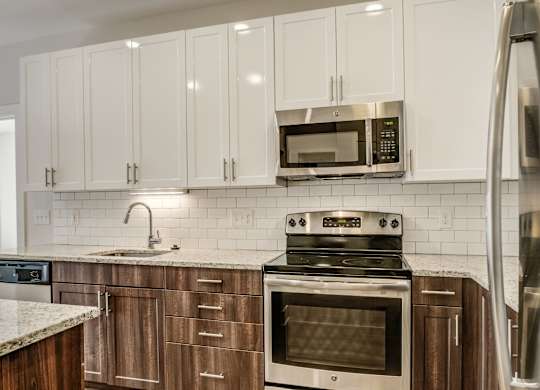A kitchen with a stove, oven, microwave, and refrigerator.