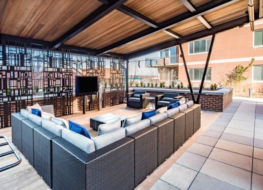 an outdoor patio with couches and a tv