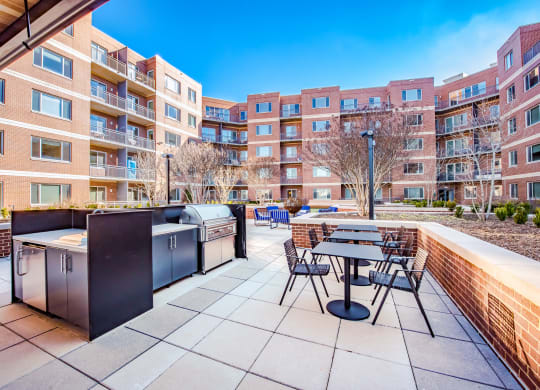 an outdoor patio with tables and chairs and a large apartment building