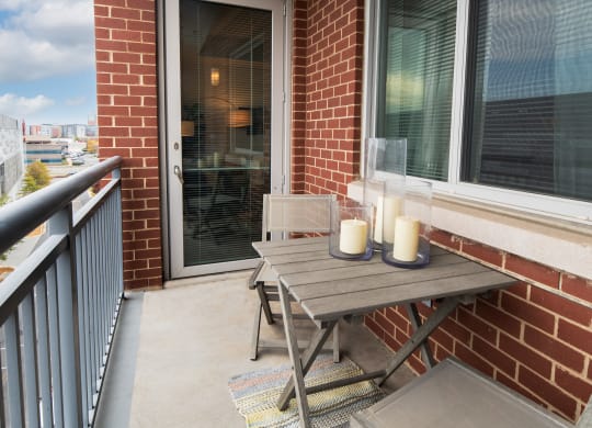 a patio with a wooden table and two candles on it