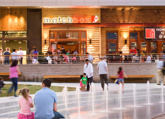 people outside of a mall with a water fountain