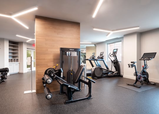 a gym with various machines and weights on the floor