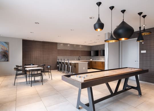 a communal table in a room with a kitchen and dining area