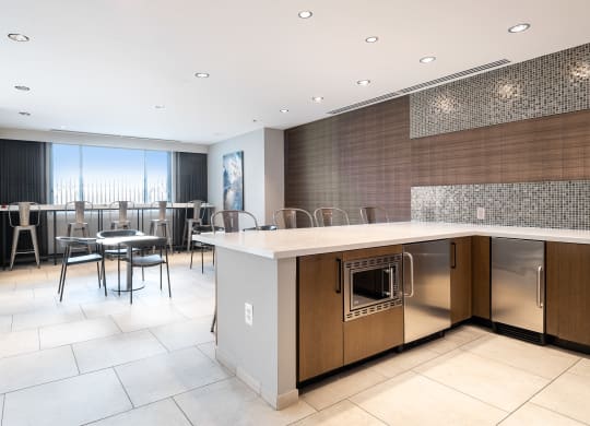 a large kitchen with an island and a dining room with chairs