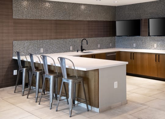 a kitchen with bar stools in front of a counter top