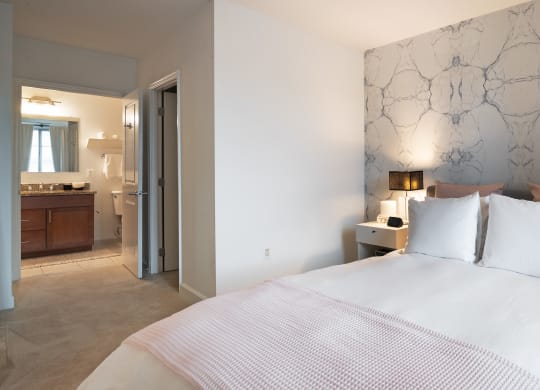 a bedroom with a bed and a bathroom with a sink