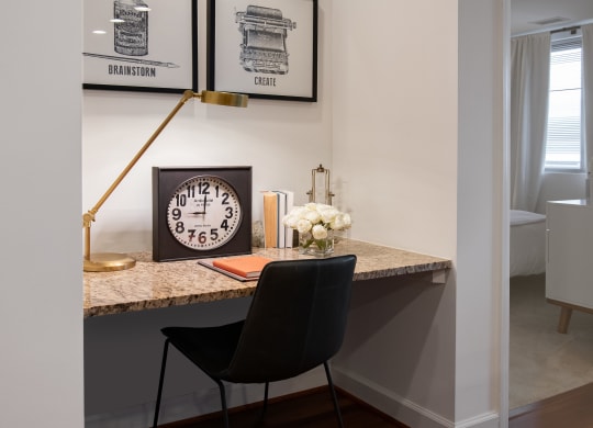 a desk with a clock and a chair in a living room
