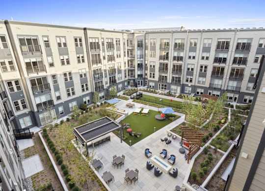 A courtyard with a fountain and seating area surrounded by apartment buildings.