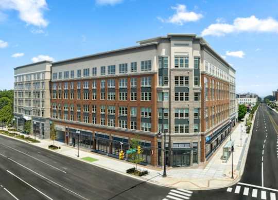 A street view of a multi-story building with a clear blue sky above.