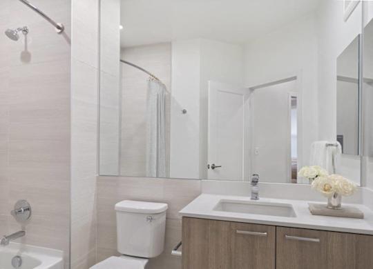 A white toilet sits next to a sink in a bathroom.