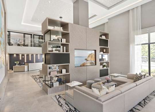 A modern living room with a large grey sofa and a television.