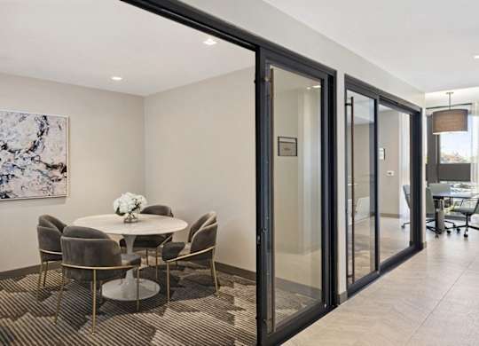 A modern dining room with a glass table and chairs.
