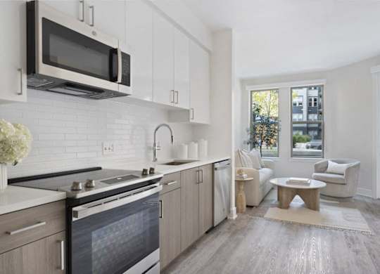 A modern kitchen with a stove top oven and a microwave above it.