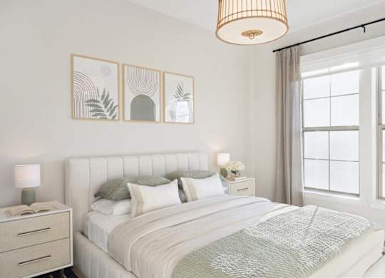 A bedroom with a large bed, a nightstand with a lamp, and a painting on the wall.