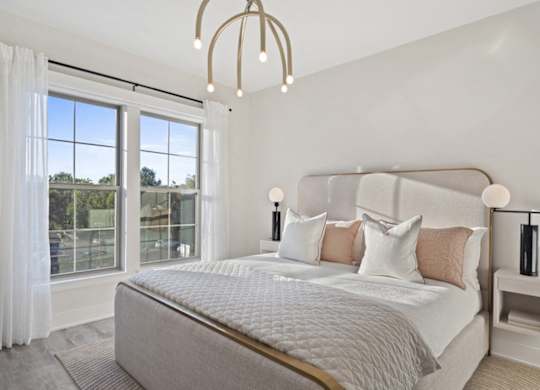A bedroom with a large bed and a chandelier.