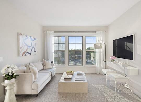 A living room with a couch, a coffee table, a television, and a painting on the wall.