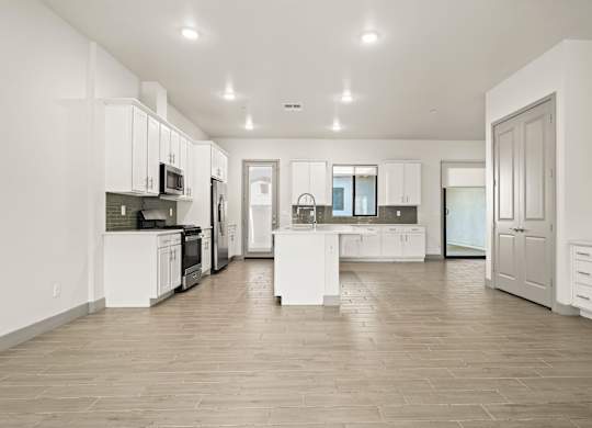 A spacious kitchen with white cabinets and a central island.